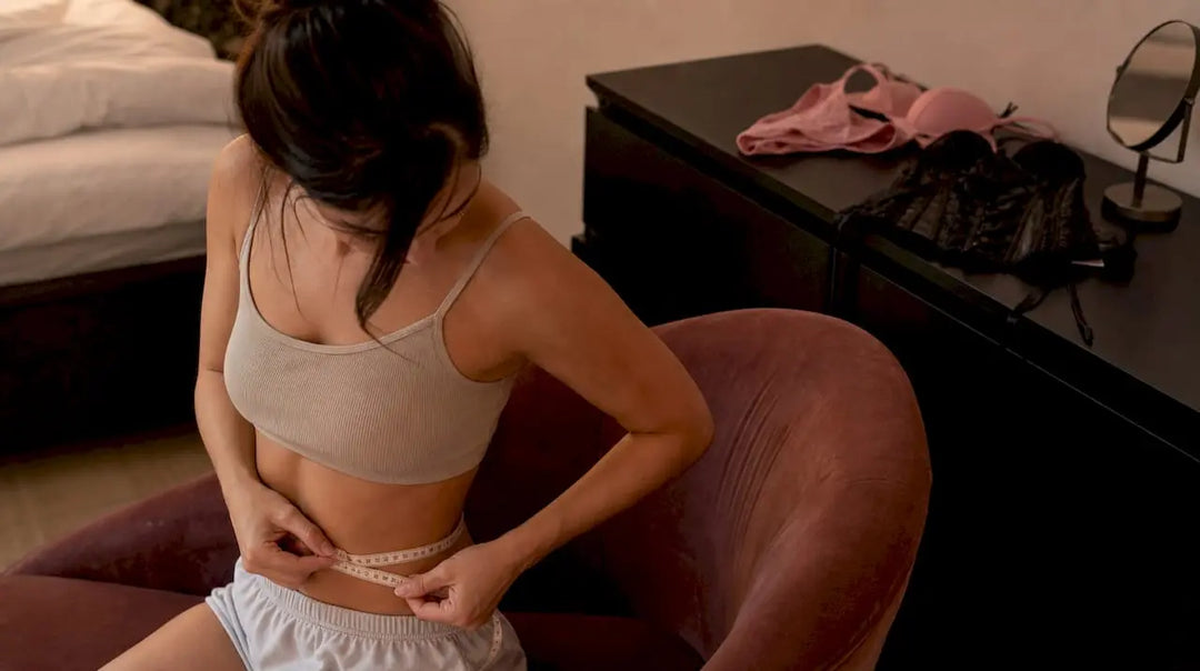 Woman measuring waist with tape