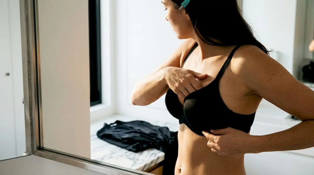 Woman performing a bra scoop-and-swoop adjustment